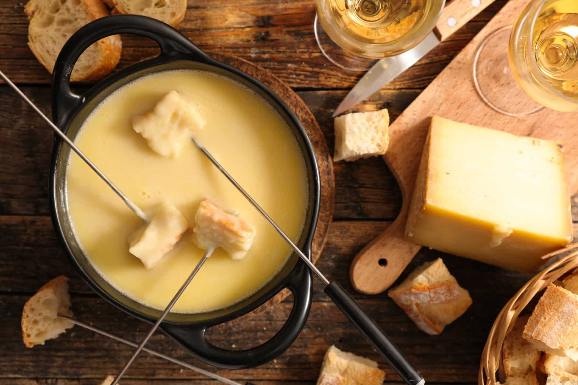 Verres de vin blanc sec à côté d'une fondue savoyarde