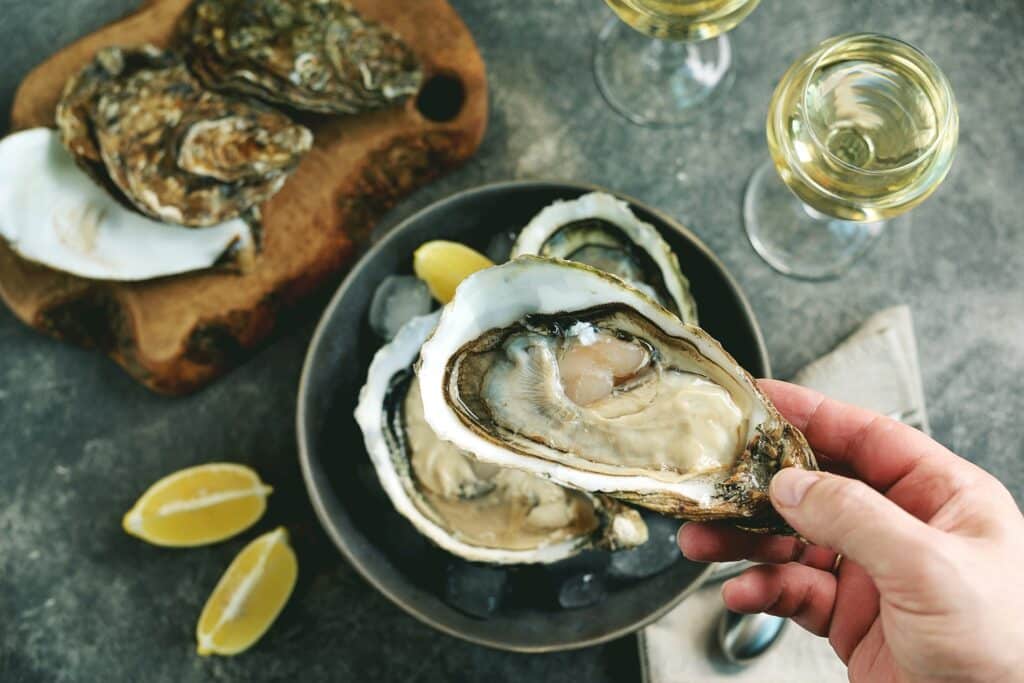 Huîtres crues fraîches géantes dans une coquille avec du citron sur glace. Nourriture saine.